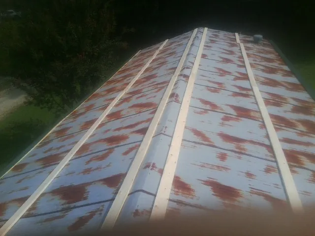 Rusted metal roof panels with new wood purlins before replacement — Storm Damage Roof Repair in Bullock by Roofing Brothers
