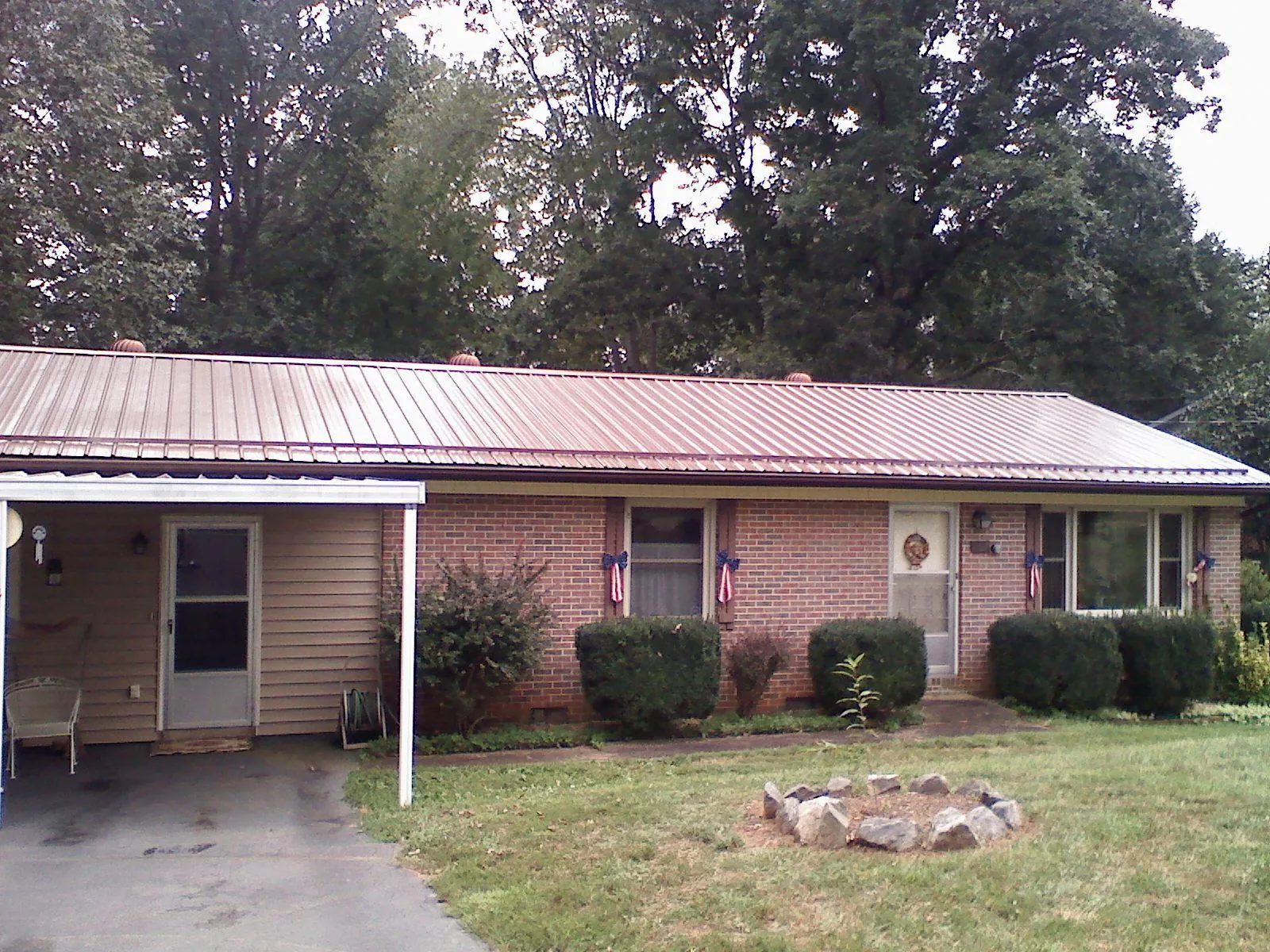 Bronze metal roof and carport on a brick ranch home — Roof Repair work by our crew in Bullock