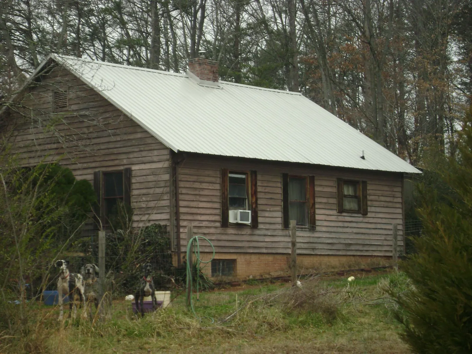 White metal roof on an old wood sided farmhouse, from a Metal Roof Installation job in Bullock